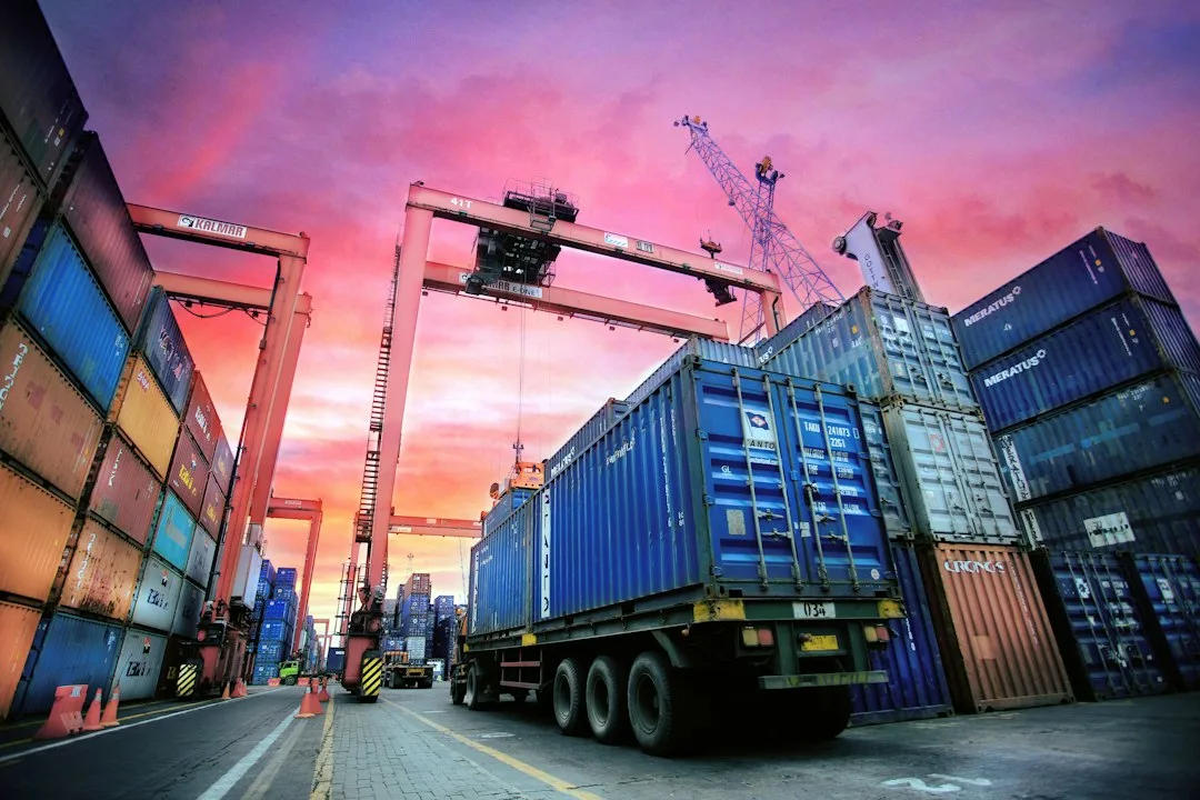 Hệ Thống Quản Lý Xe Ra Vào Cảng, ICD, Kho Logistics, Nhà Máy, Khu Công Nghiệp 15 Container xếp chồng tại cảng lúc hoàng hôn, nơi cần điều phối xe vào ra theo lịch
